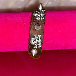 Vintage leather bracelet with metal skulls and spikes